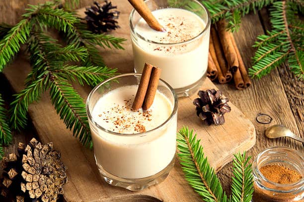 A holiday coffee drink and cookies sit on a white surface